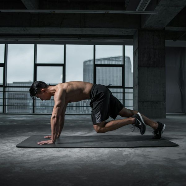 A focused man doing a core-strengthening plank exercise on a mat.
